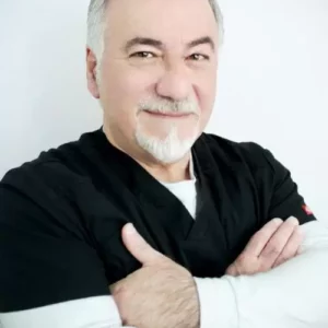 Dr. Val, European male with gray hair, black shirt with white sleeves and arms crossed